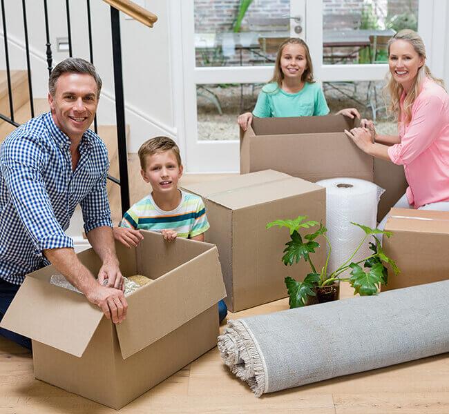 Family moving into their new home unpacking boxes